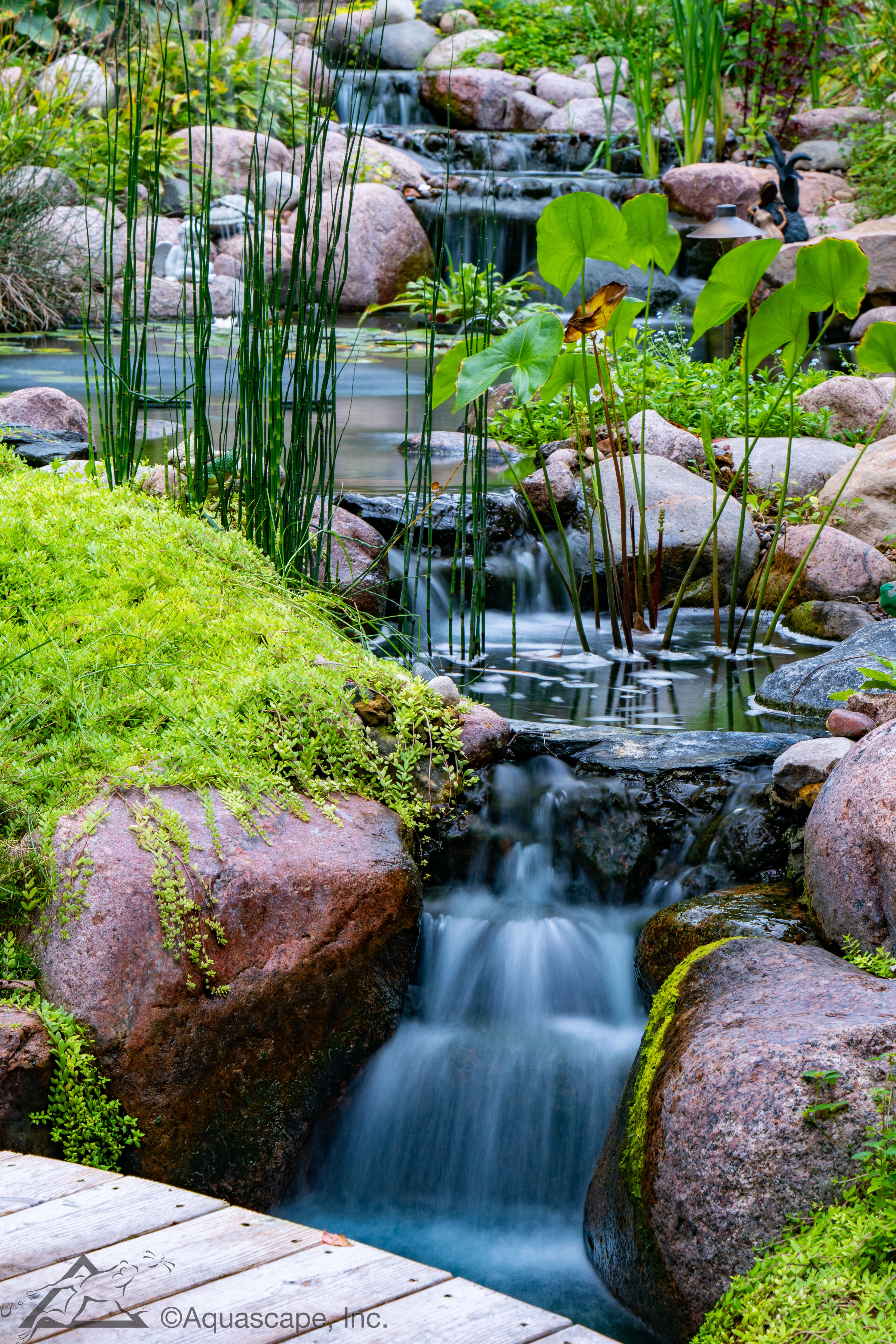 Backyard pondless waterfall near a patio seating area