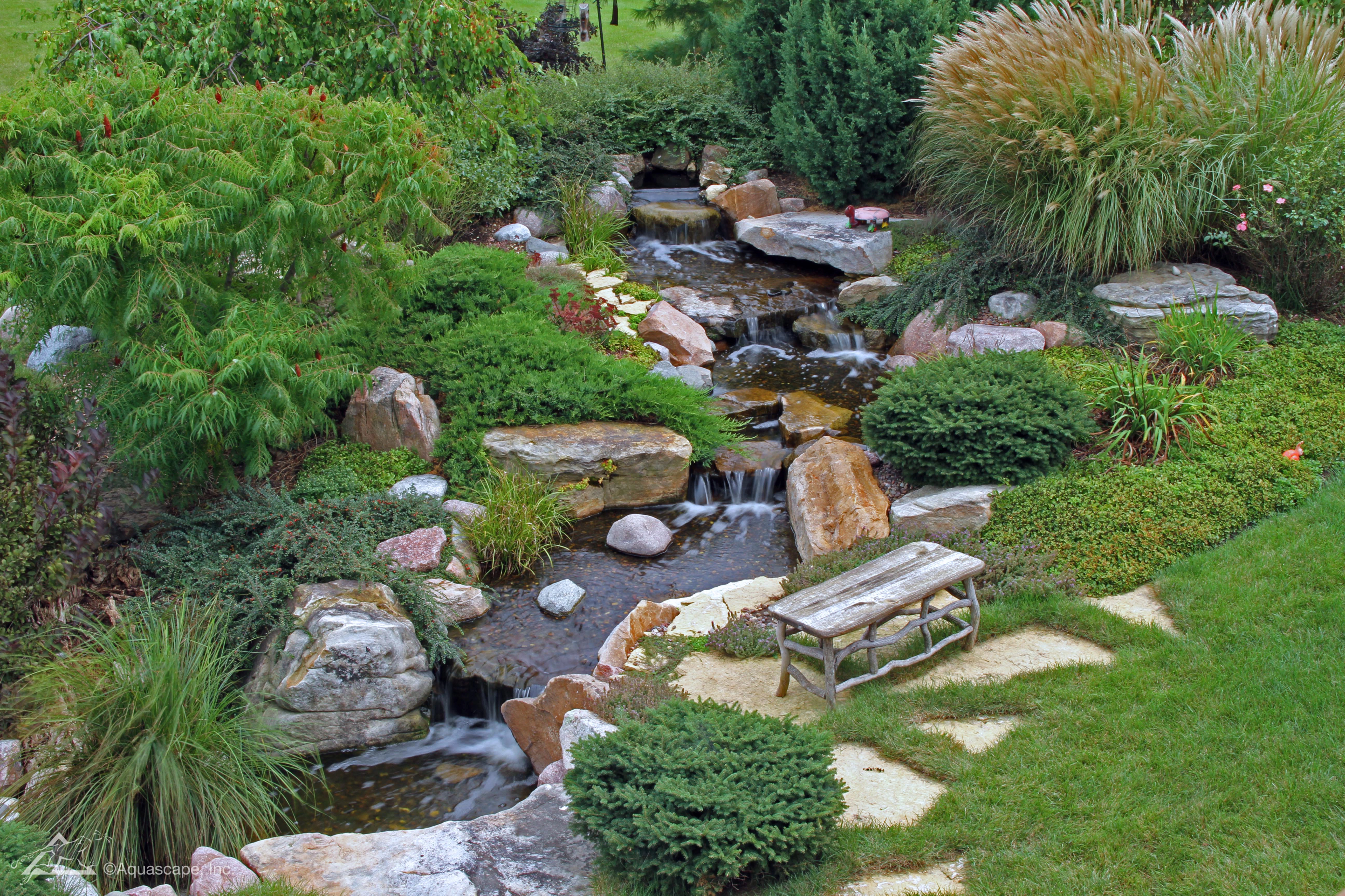 Premium backyard pondless waterfall with natural stone and flowing water