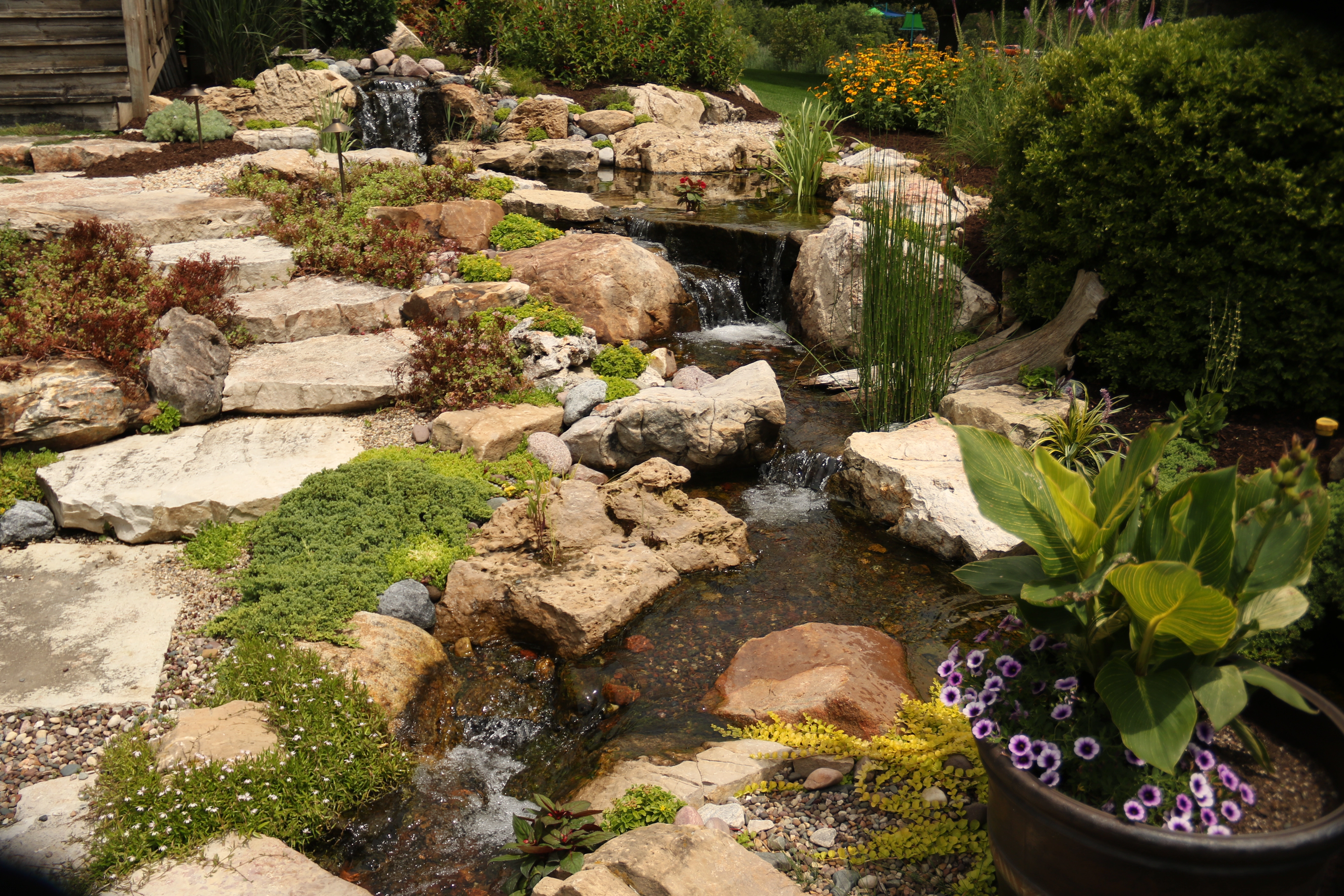 Natural pondless waterfall with boulders and stream in Burnsville Minnesota
