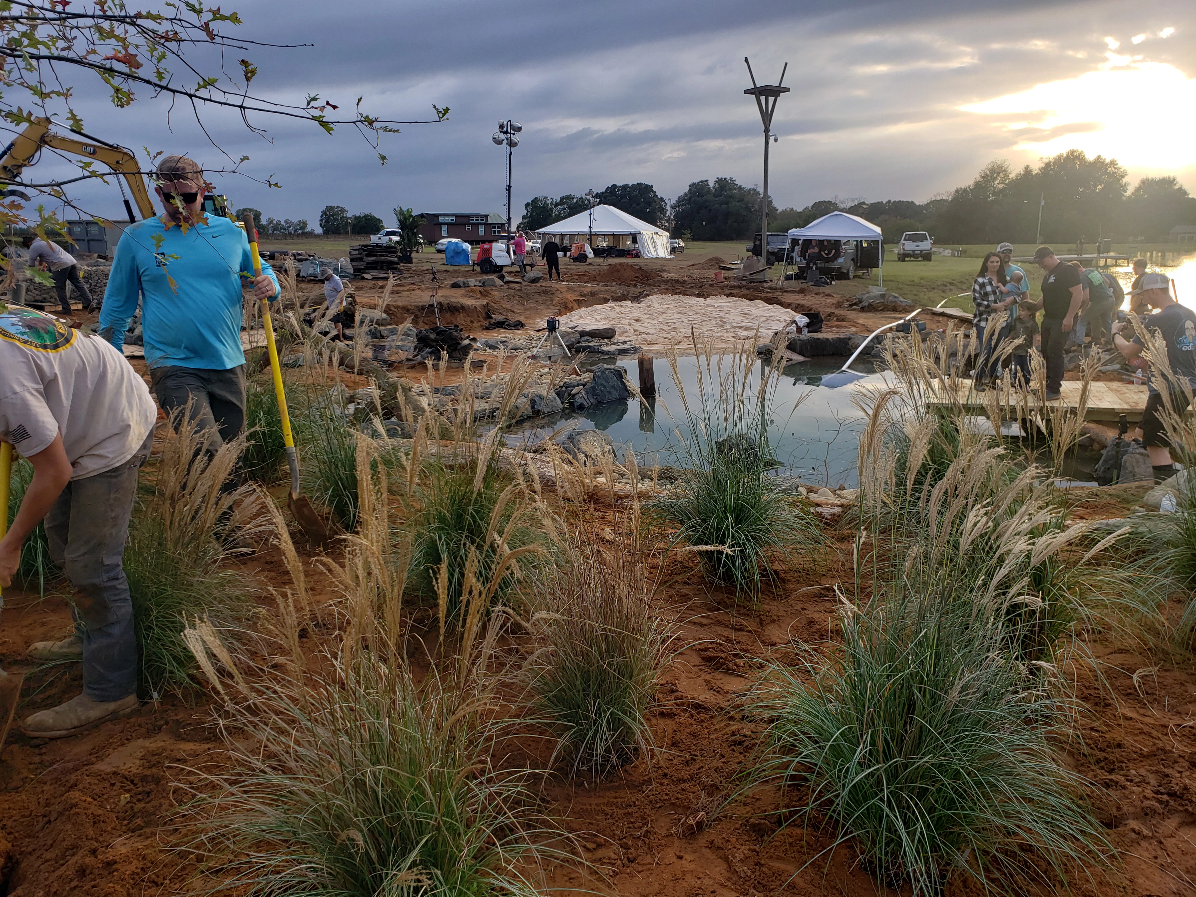 Waterfall landscape planting process with ornamental grasses and natural pond edge