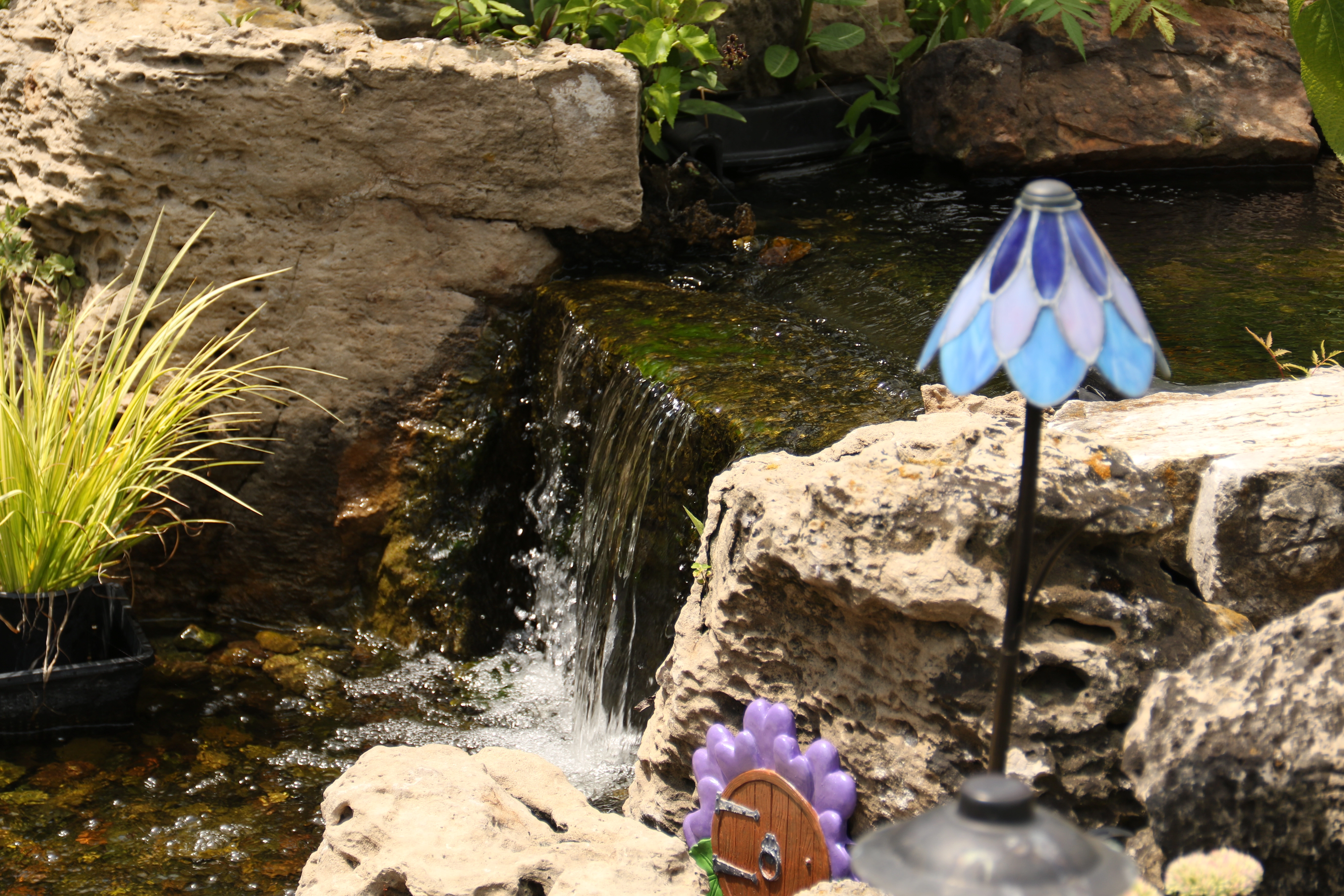 Closeup of moving water flowing over a pond waterfall
