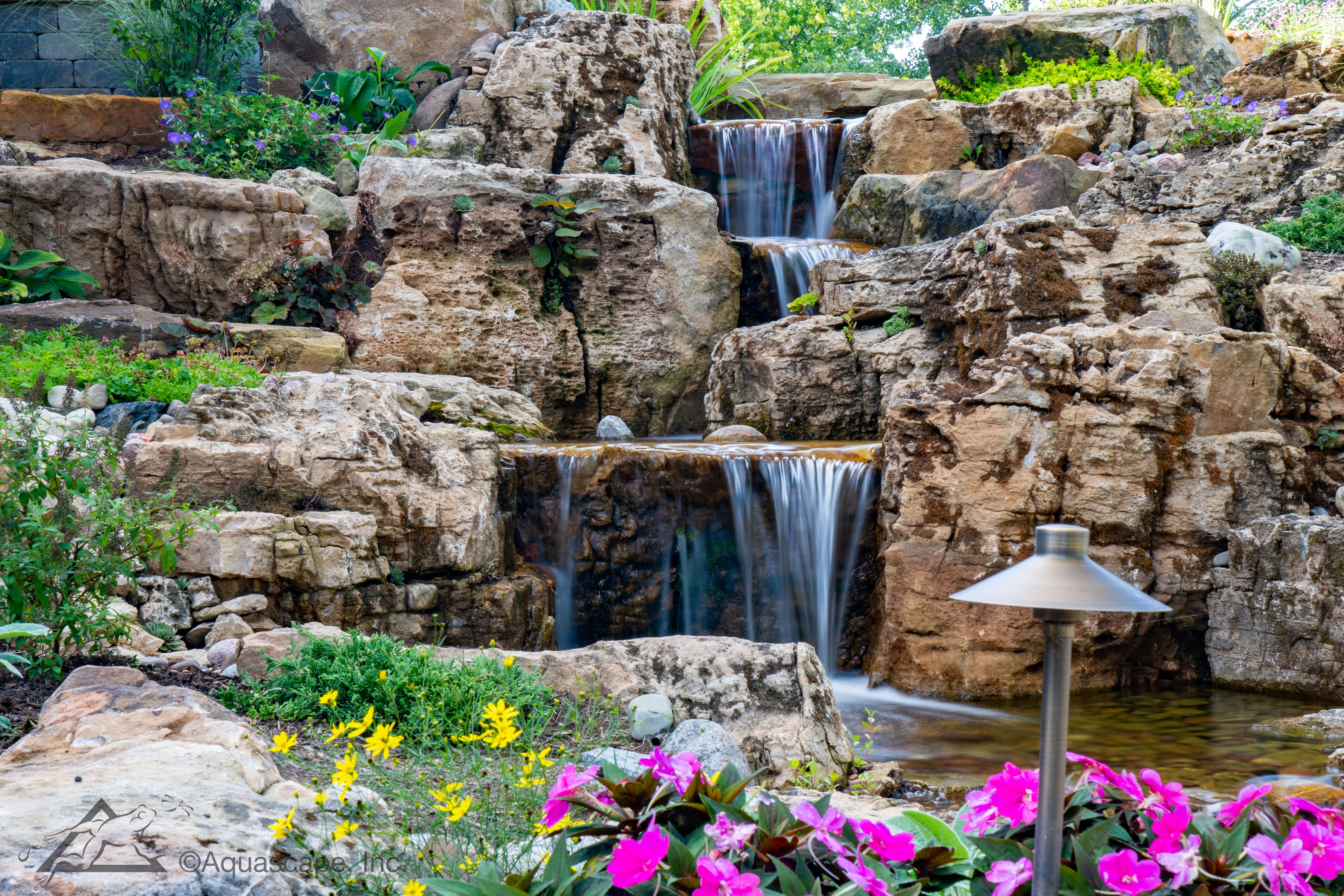 Backyard pondless waterfall with natural stone and landscape planting in Granite Falls Minnesota