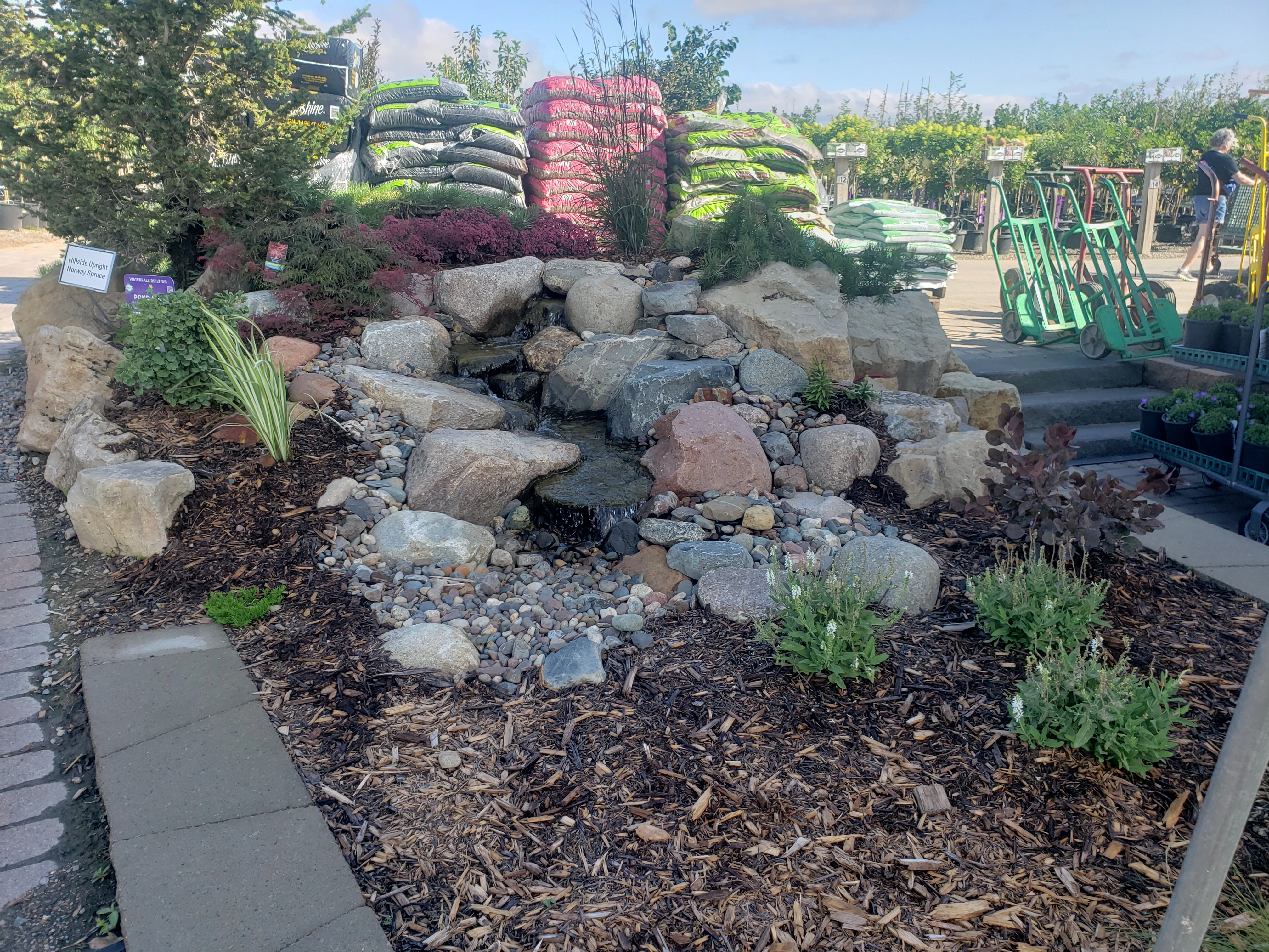 Finished pondless waterfall installation with natural stone and flowing water