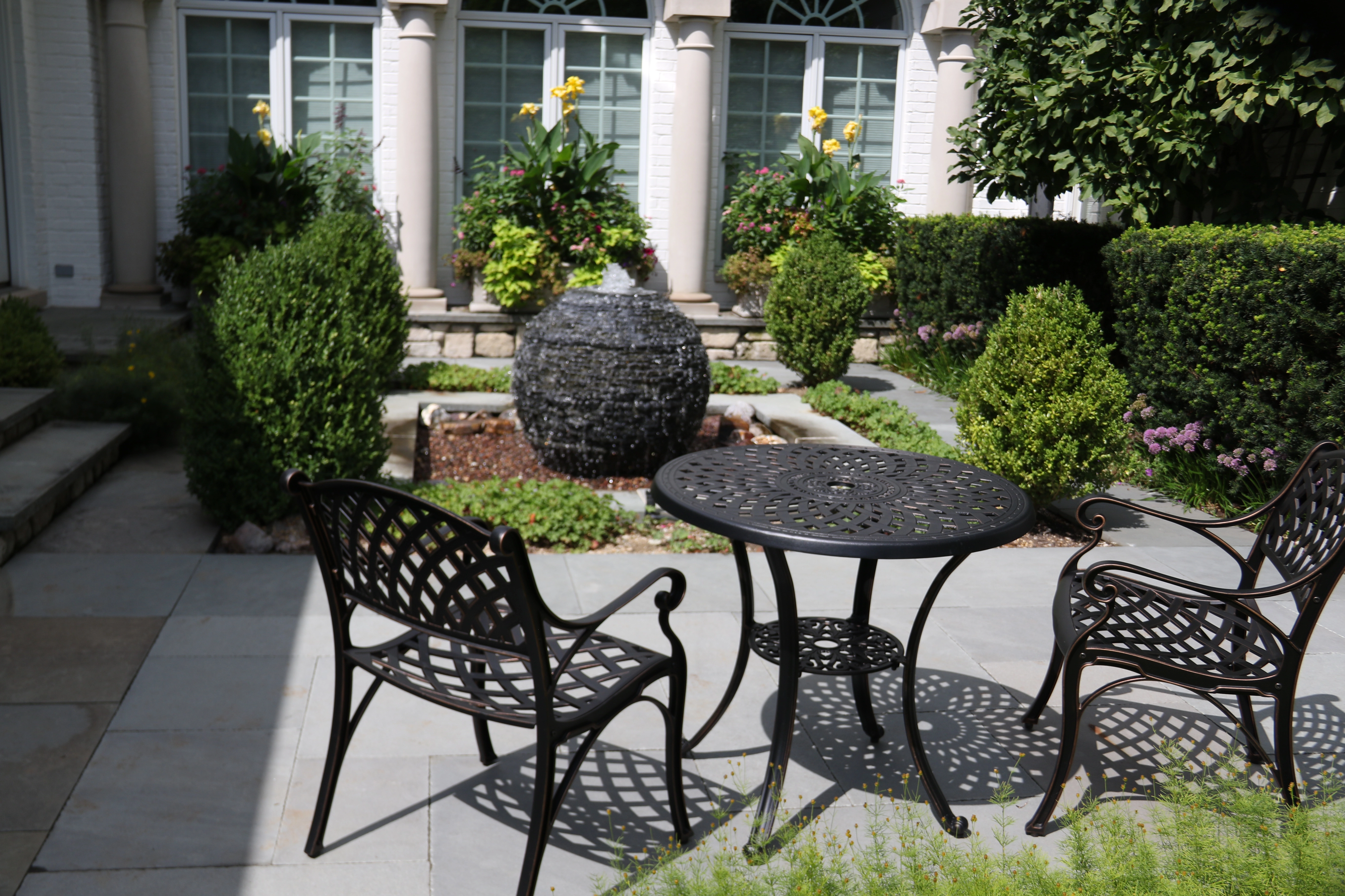 Backyard seating area with a small pondless waterfall and landscape lighting in Marshall Minnesota