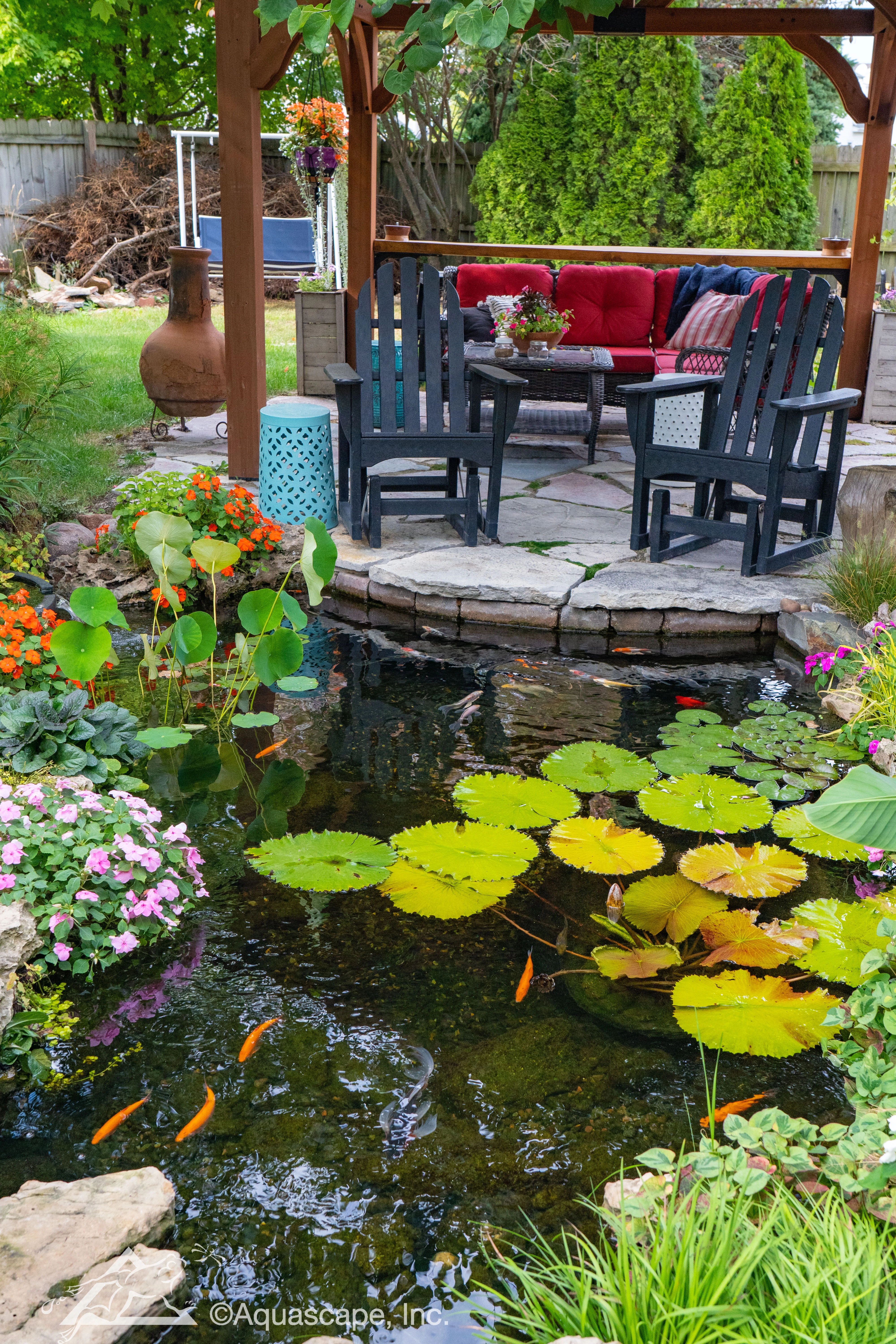 Backyard ecosystem pond with pergola seating area in North Oaks Minnesota