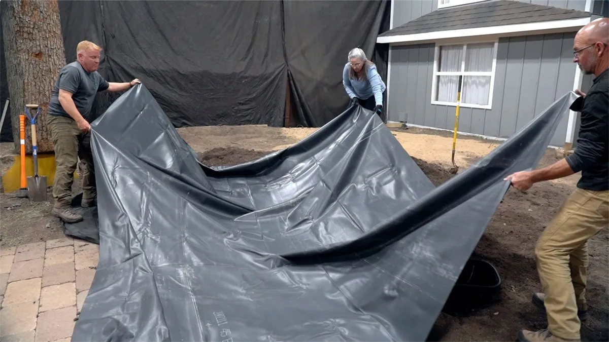 Underlayment and liner installed during backyard pond construction
