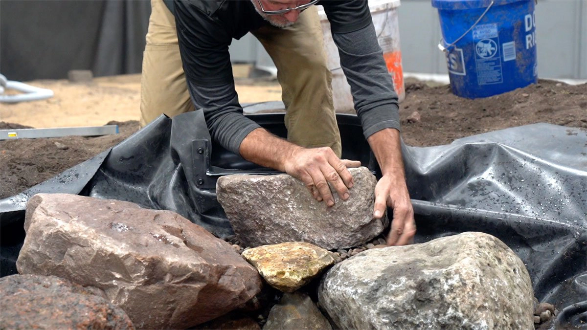 Waterfall construction during backyard ecosystem pond installation