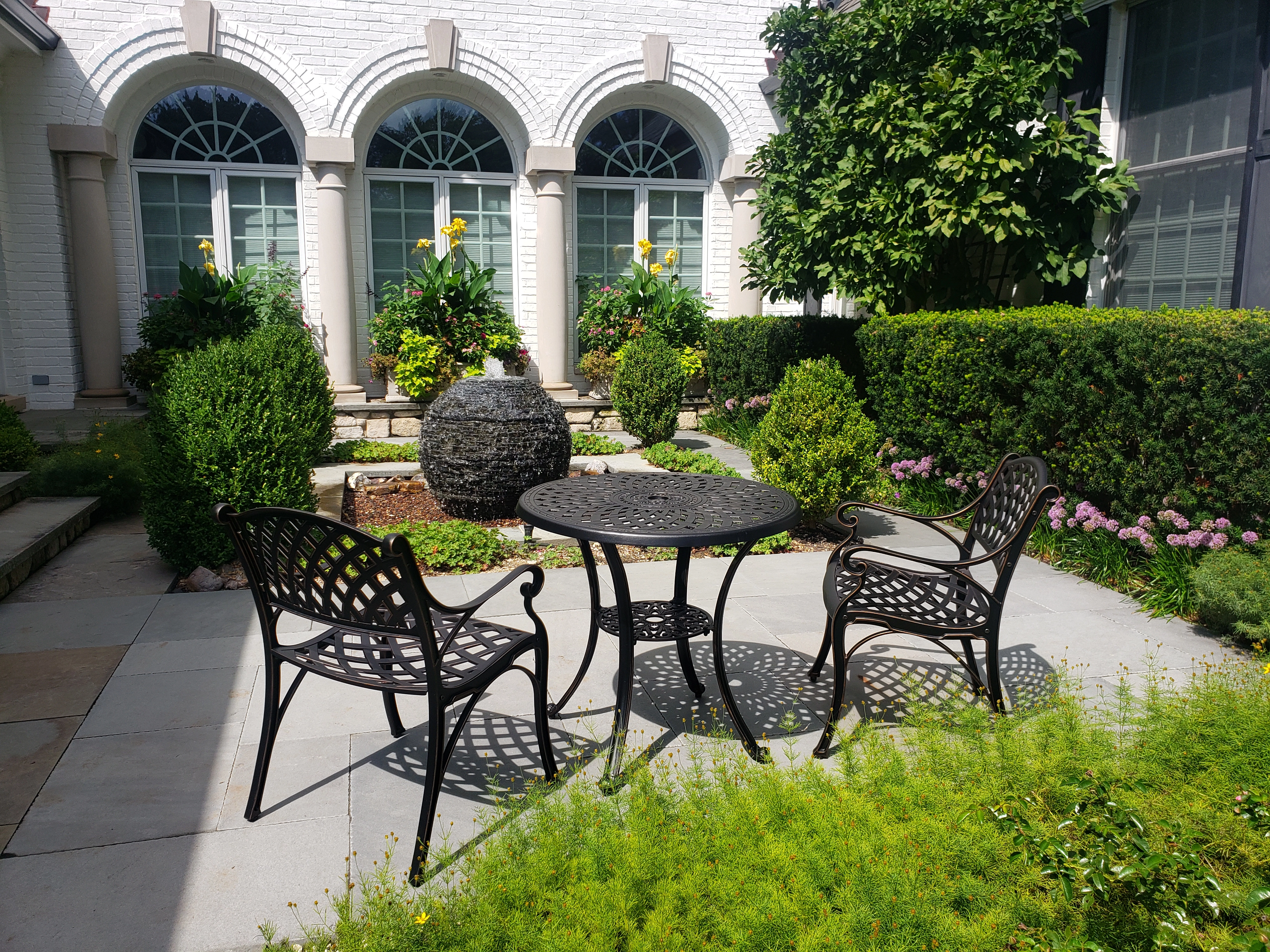 A large stacked slate sphere fountain in a courtyard
