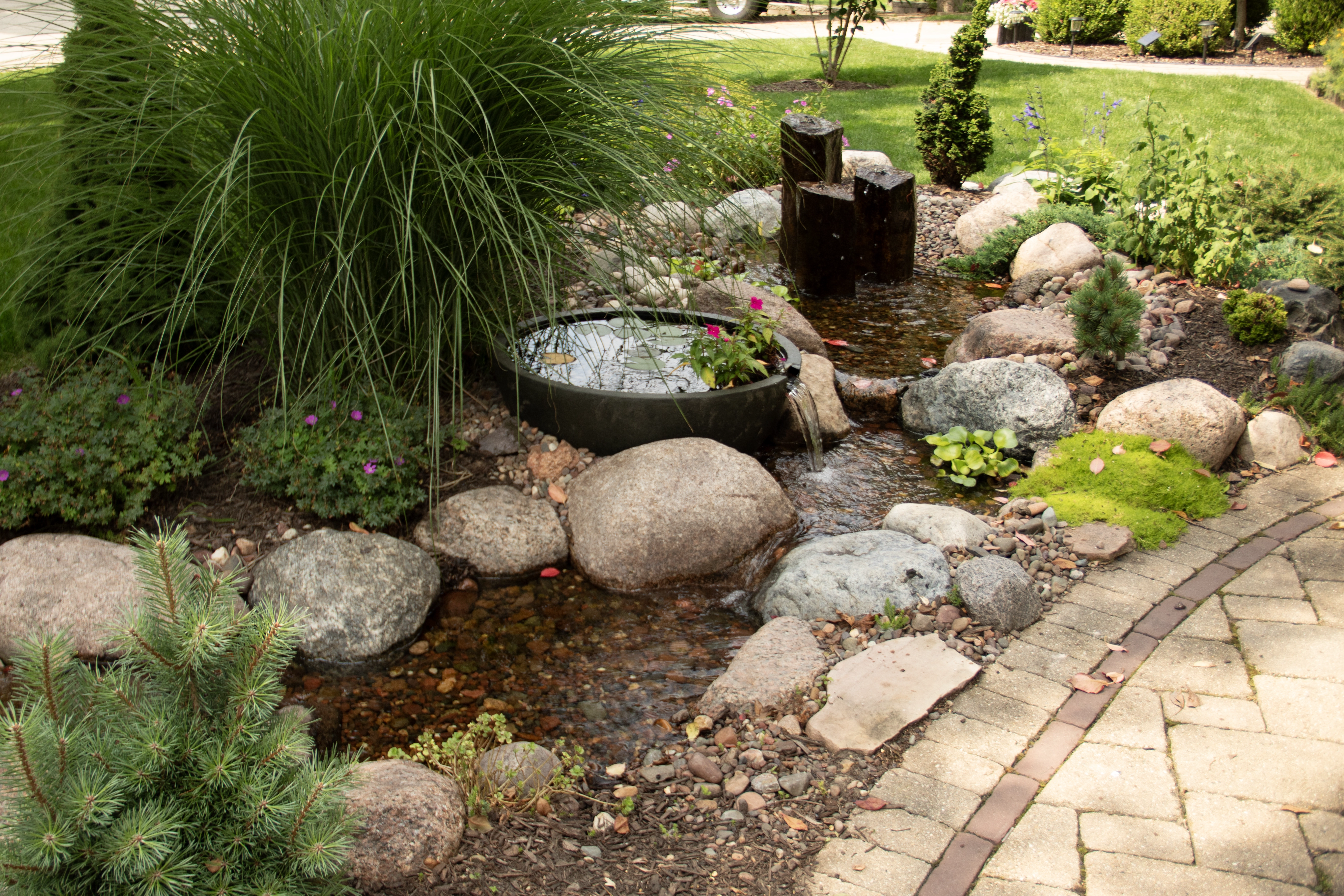 Using fountains to add verticality to a pondless waterfall