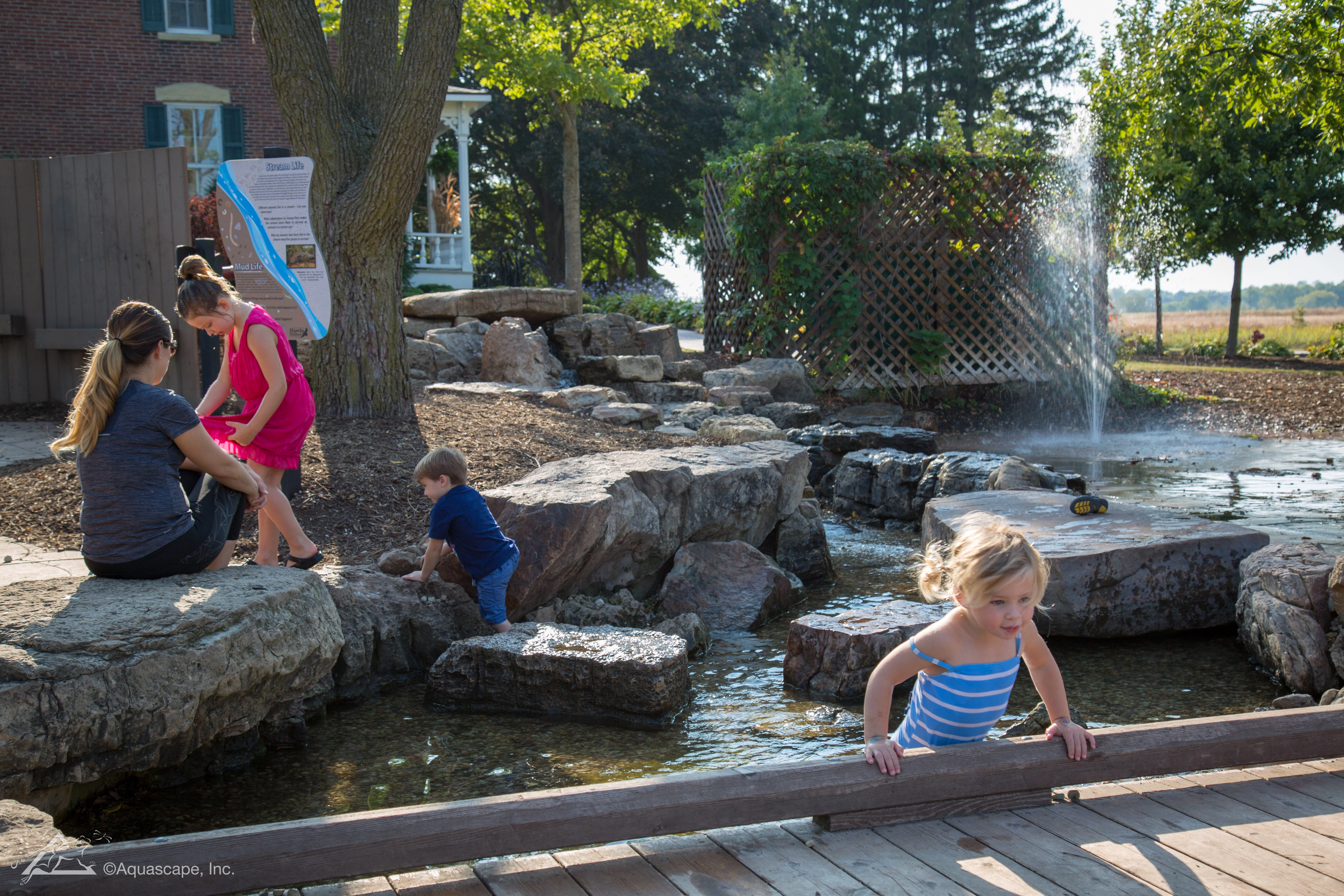 Family enjoying a backyard ecosystem pond and fountain in Shakopee Minnesota