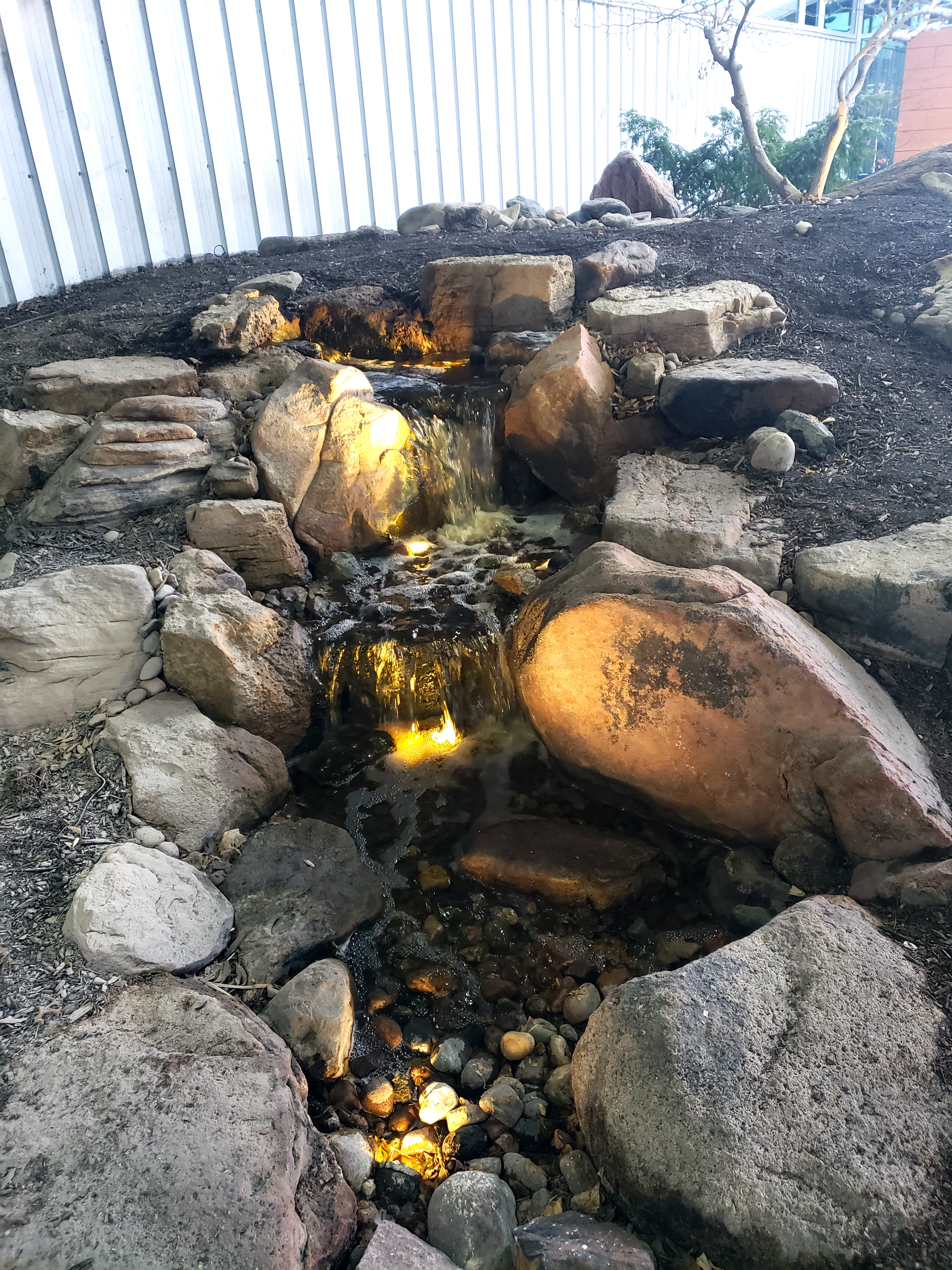 Pondless waterfall with lighting for a Tonka Bay Minnesota backyard