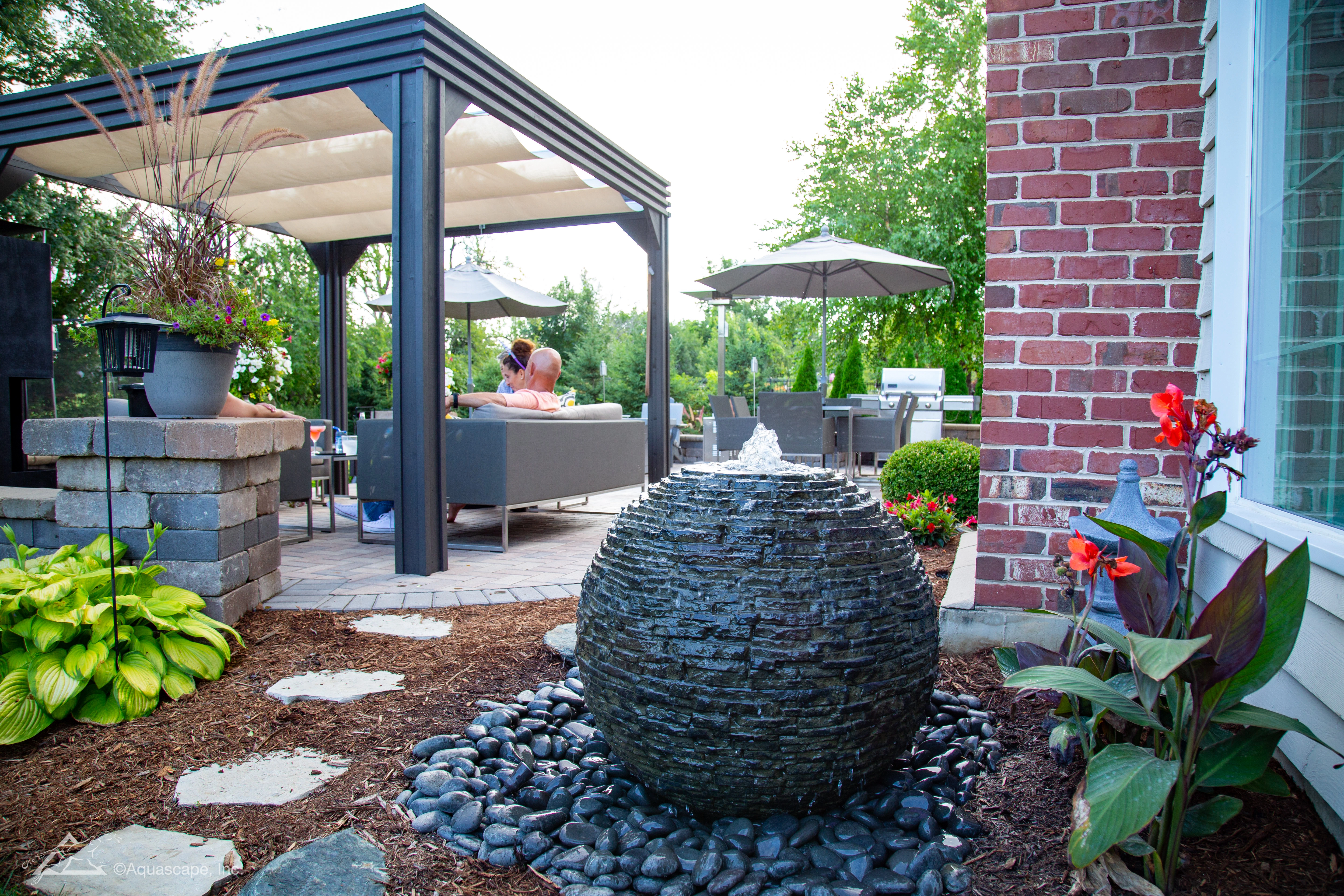 Small backyard fountainscape integrated near a patio seating area